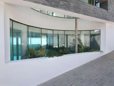 a building with glass windows and plants on the side at Phenomenal Algarve Villa Villa Flowerscape 4 Bedrooms Steam Room & Home in Almancil