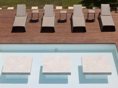 a row of benches sitting next to a swimming pool at Phenomenal Algarve Villa Villa Flowerscape 4 Bedrooms Steam Room & Home in Almancil