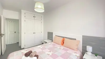 a bedroom with a bed with two slippers on it at Quarteira Frente Praia II by HomeSlow Rentals in Quarteira