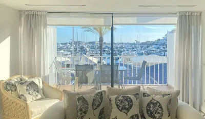 a living room with a couch and a large window at Intemporal Duplex Marina T2 HsR Marina Vilamoura in Vilamoura