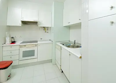 a white kitchen with white cabinets and a sink at Intemporal Duplex Marina T2 HsR Marina Vilamoura in Vilamoura
