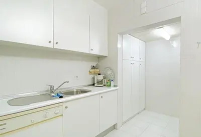 a white kitchen with a sink and white cabinets at Intemporal Duplex Marina T2 HsR Marina Vilamoura in Vilamoura