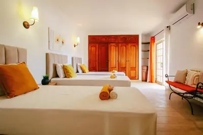 a hotel room with two beds and a chair at Villa Punta Cana by Algarve Vacation in Albufeira