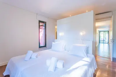 a white bedroom with a large white bed with white pillows at Villa Adelaide in Quarteira