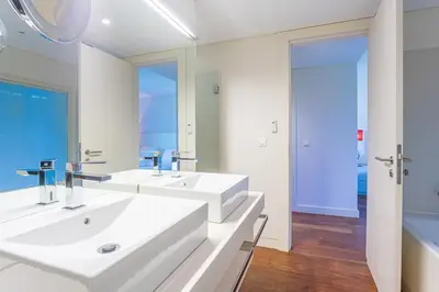 a bathroom with two sinks and a large mirror at Villa Adelaide in Quarteira