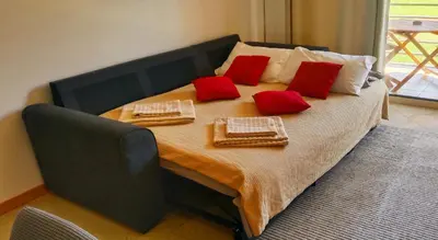 a large bed with red pillows on top of it at Encosta Da Orada in Albufeira