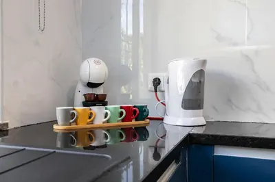 a kitchen counter with cups and a coffee maker at Apartment in São Rafael Albufeira Beach Resort in Albufeira