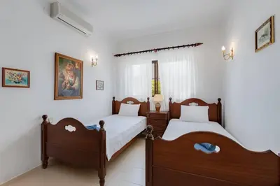 two beds in a bedroom with white walls at VILLA ROSADO - Moradia para 6 com AC, jardim a 5 min do centro de Albufeira in Albufeira