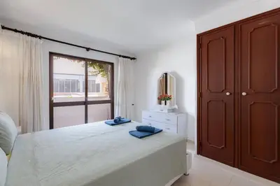a bedroom with a bed and a large window at VILLA ROSADO - Moradia para 6 com AC, jardim a 5 min do centro de Albufeira in Albufeira