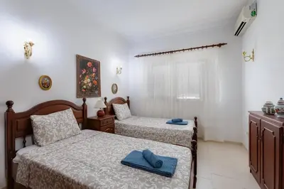a bedroom with two beds with towels on them at VILLA ROSADO - Moradia para 6 com AC, jardim a 5 min do centro de Albufeira in Albufeira