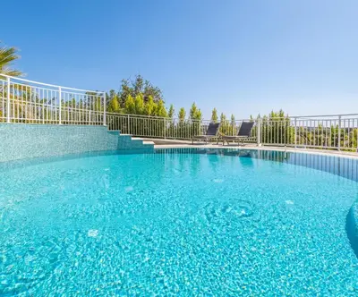 a large swimming pool with blue water and a fence at Townhouse Varadero by Algarve Vacation in Albufeira