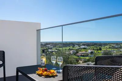 a table with wine glasses and a bowl of fruit on a balcony at Townhouse Varadero by Algarve Vacation in Albufeira
