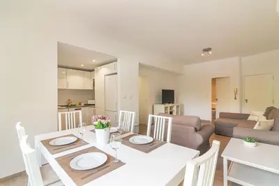 a kitchen and living room with a white table and chairs at Vilamoura M.M. Sunrise T2 in Vilamoura