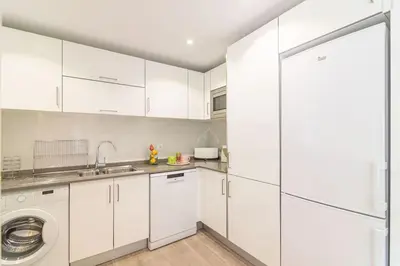 a kitchen with white cabinets and a washing machine at Vilamoura M.M. Sunrise T2 in Vilamoura