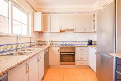 a kitchen with white cabinets and a sink and a window at Villa Periquito 2BD Pool Fast WiFi AC Garden in Albufeira
