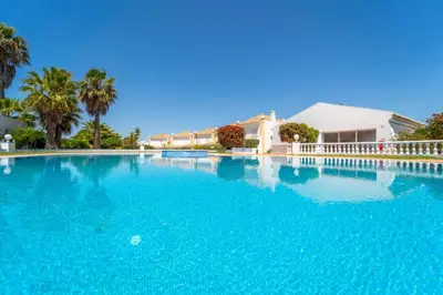 a large pool of blue water in front of a house at Villa Periquito 2BD Pool Fast WiFi AC Garden in Albufeira