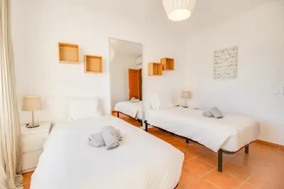two beds in a room with white walls at Villa Periquito 2BD Pool Fast WiFi AC Garden in Albufeira
