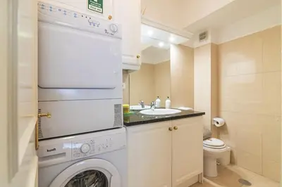 a small bathroom with a washing machine and a sink at Vilamoura M.M. Holidays T2 in Vilamoura