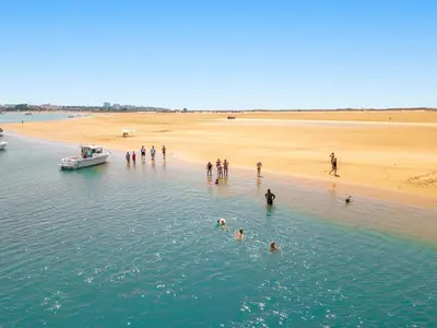 a group of people standing in the water near a beach at Villa Isla Bella by Algarve Vacation in Albufeira
