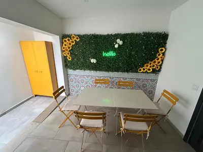 a table and chairs in a room with a wall with flowers at Boutique Style Town House in Albufeira