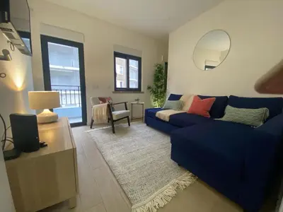 a living room with a blue couch and a mirror at Boutique Style Town House in Albufeira