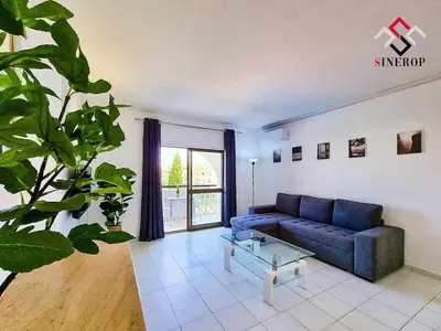 a living room with a blue couch and a table at Apartamento T1 - Valmangude in Albufeira