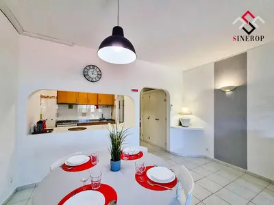a dining room with a table and a clock on the wall at Apartamento T1 - Valmangude in Albufeira