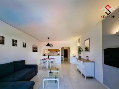 a living room with a couch and a kitchen at Apartamento T1 - Valmangude in Albufeira