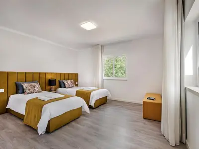 a bedroom with a bed and a chair and a window at Villa Aladdin - VIP Properties by Interhome in Albufeira