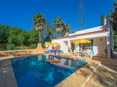 a swimming pool with umbrellas and a house at Villa Maria by Interhome in Albufeira