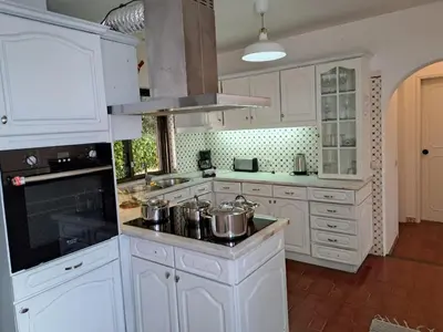 a kitchen with white cabinets and pots on the stove at Villa Libertos V4 - VIP Properties by Interhome in Albufeira