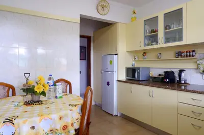 a kitchen with a table and a refrigerator at Ria Formosa Pineview in Faro