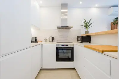 a white kitchen with white cabinets and a stove at Balaia apartment at Albufeira in Albufeira