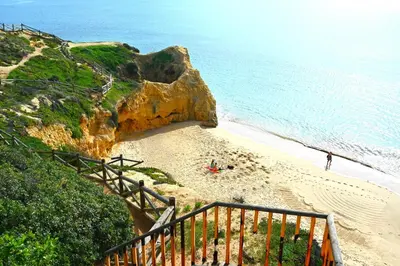 a staircase leading down to a beach with the ocean at Balaia apartment at Albufeira in Albufeira