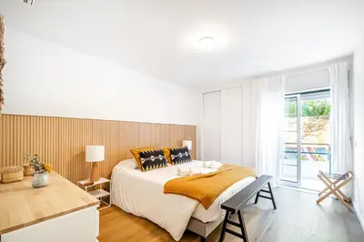 a white bedroom with a large bed and a window at BeGuest Falesia Beach & Garden in Albufeira