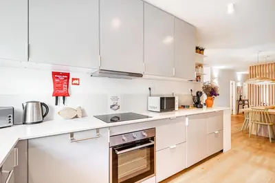 a white kitchen with white cabinets and appliances at BeGuest Falesia Beach & Garden in Albufeira
