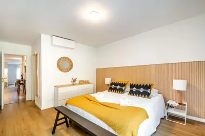 a bedroom with a large bed with a yellow blanket at BeGuest Falesia Beach & Garden in Albufeira
