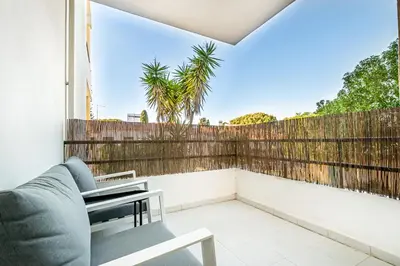 a balcony with a couch and a fence at BeGuest Falesia Beach & Garden in Albufeira