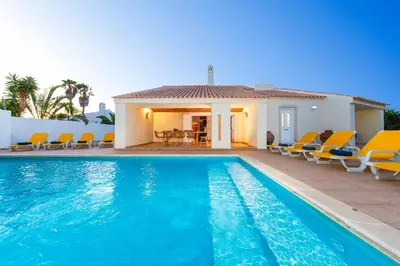 a villa with a swimming pool and chairs at Villa Las Palmas by Algarve Vacation in Albufeira