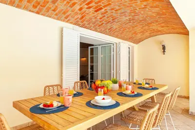 a dining room with a wooden table and chairs at Villa Las Palmas by Algarve Vacation in Albufeira