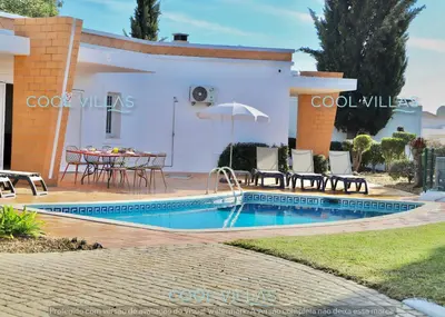 a villa with a swimming pool and a table and chairs at Orquidea Senses - 6 Pax - Sea View in Albufeira
