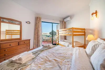 a bedroom with a bed and a dresser and a mirror at Vilamoura Sea View in Vilamoura