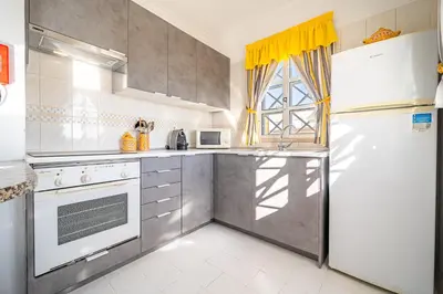 a kitchen with stainless steel appliances and a white refrigerator at Vilamoura Sea View in Vilamoura