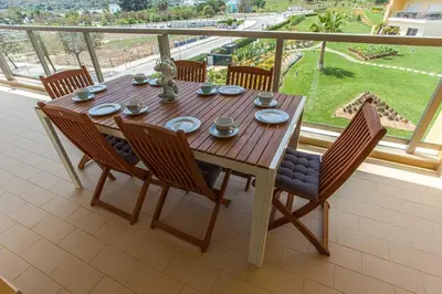 a wooden table and chairs on a balcony at Sir Anthony Luxury in Albufeira