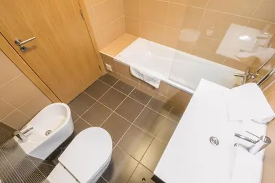 a bathroom with a toilet and a sink and a tub at Sir Anthony Luxury in Albufeira