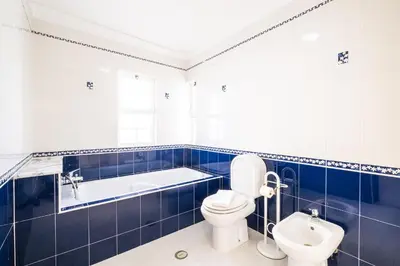 a bathroom with a toilet and a tub and a sink at Villa Ventura Heritage in Albufeira