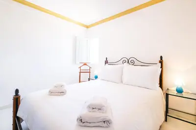a bedroom with a white bed with towels on it at Villa Ventura Heritage in Albufeira