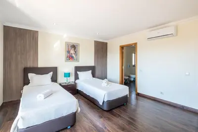 a bedroom with a white bed and a large mirror at VILLA Simao in Guia