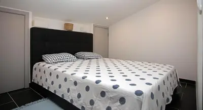 a bedroom with a bed with a black headboard and two pillows at Geneve Old Town Apartment in Albufeira