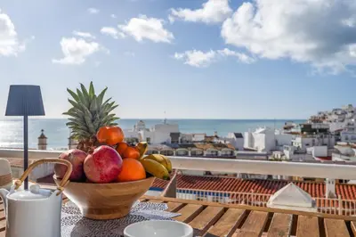 a bowl of fruit on a table with a view of the ocean at Deluxe Flat by Albufeira Holidays in Albufeira